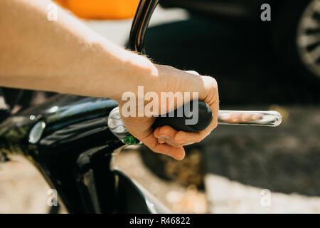 Der Tourist wird einen Elektroroller zu verwenden. Close-up Hand. Beliebte Fahrzeug in Berlin in Deutschland. Stockfoto