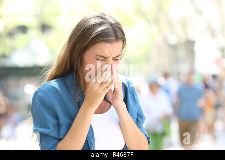 Kranke Frau Blasen auf einem Papiertuch auf der Straße an einem sonnigen Tag Stockfoto