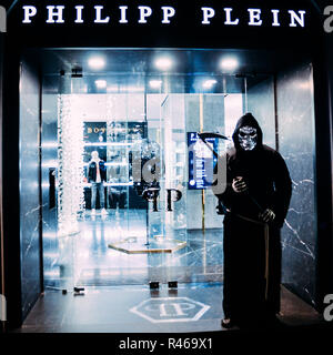 Person, die so tut, als der Sensenmann vor einem Philipp Plein Einzelhandelsgeschäft in San Babila, Mailand, Lombardei, Italien vor der festlichen Jahreszeit Stockfoto