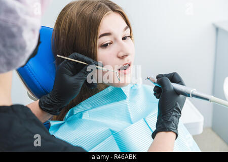 Zahnmedizinische Klinik. Rezeption, die Untersuchung des Patienten. Zähne kümmern. Zahnarzt Heilen ein Mädchen patient Stockfoto