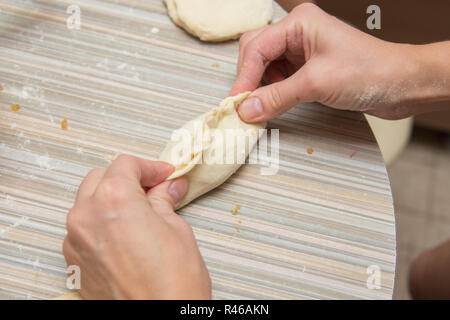 Weibliche Hand geformten Kuchen auf dem Küchentisch Stockfoto