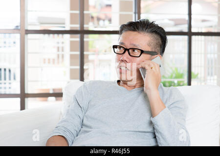 Reifen asiatischer Mann Aufruf auf dem Smartphone Stockfoto