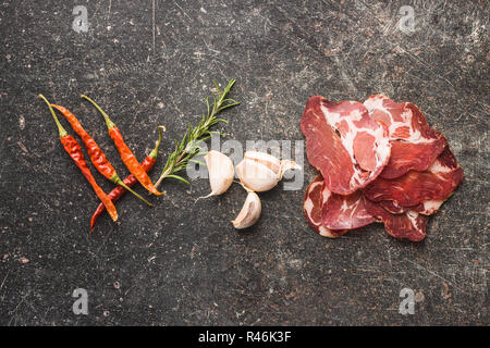 Getrocknetes Schweinefleisch Schnitte, Knoblauch, Rosmarin und Peperoni. Stockfoto