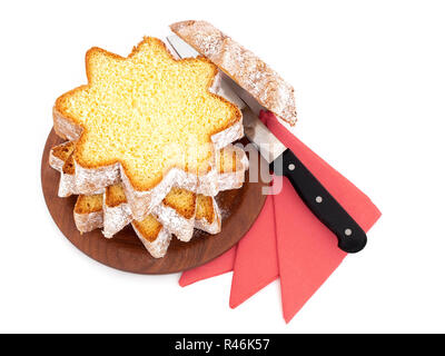 In Scheiben geschnitten Pandoro, süßen italienischen Hefe Brot, traditionelle Weihnachten behandeln. Mit roten Servietten und Messer auf Weiß. Overhead flach anzeigen. Stockfoto