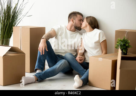 Liebevolle junge Paar küssen, Holding hands in neue Wohnung Stockfoto