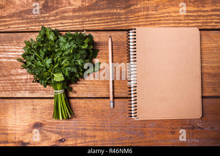 Leeres Notizbuch und Bleistift mit einem Bündel von Kräutern auf Holztisch Stockfoto