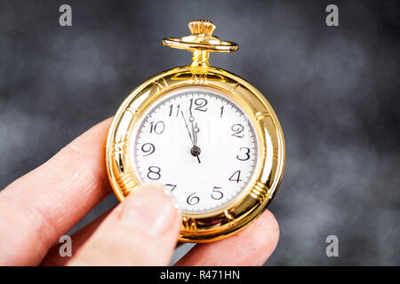 Hand, die alte Uhr nach Mitternacht Stockfoto