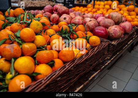 Mangerines und Granatäpfel für Verkauf am Markt in einem Weidenkorb Stockfoto