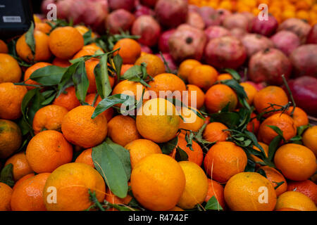 Mangerines und Granatäpfel für Verkauf am Markt in einem Weidenkorb Stockfoto