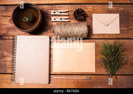 Notizbuch für Rezepte, Papier Envelopess, Seil und Wäscheklammern auf Holztisch. Stockfoto