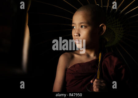 Buddhistische Novizen holding Dach Stockfoto