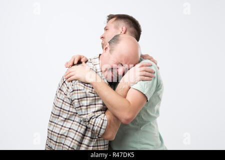 Elder Vater weint, auf seinen Sohn Schulter und Gefühl umgekippt Ursache aus seinem Fehler. Stockfoto