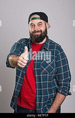 Bärtiger Mann mit Baseballmütze mit Daumen hoch Stockfoto