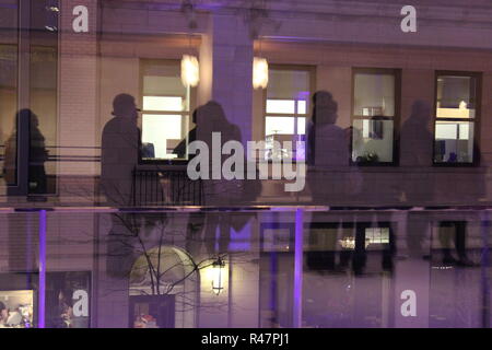 Spiegelbild im Fenster von Menschen stehen in der Linie. Stockfoto