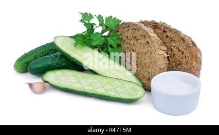 Ganze und in Scheiben geschnittene Gurken mit Salz, Scheiben von Maisbrot und Knoblauch auf weißem Hintergrund. Stockfoto
