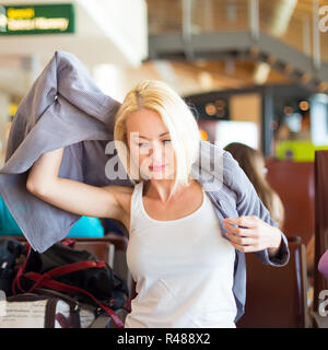 Weibliche Reisende ihre Jacke anziehen. Stockfoto