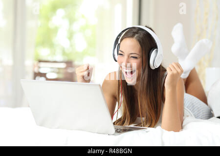 Euphorische Sieger beobachten Medien in einem Laptop Stockfoto