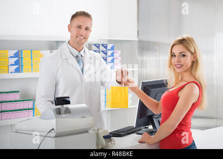 Lächelnd Apotheker, Arzneimittel an Kunden Stockfoto