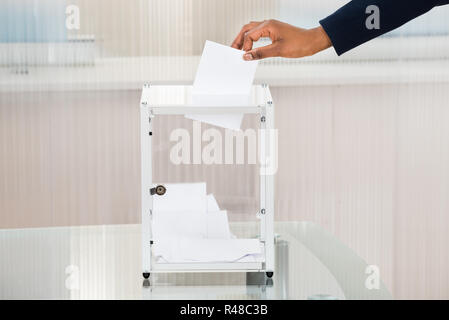 Person's Hand Stimmzettel in Feld Stockfoto