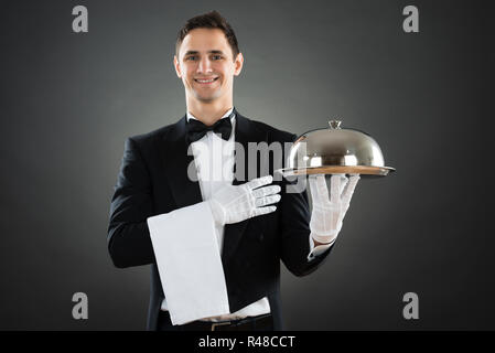 Portrait von Happy Kellner mit Tablett und Handtuch Stockfoto