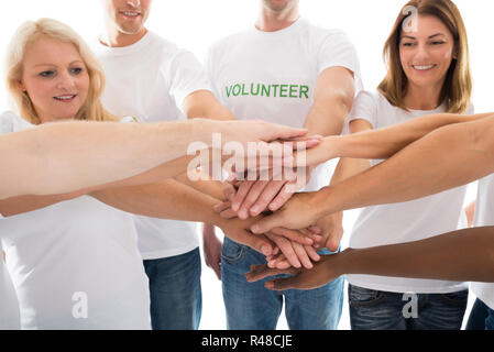 Happy multiethnischen Freiwillige Stapeln Hände Stockfoto