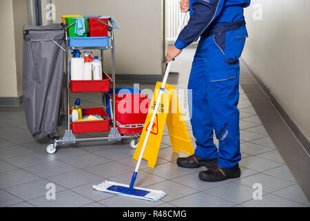 Hausmeister mit Besen Reinigung Büro Flur Stockfoto