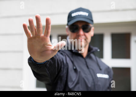 Security Guard, Stop Geste außerhalb von Gebäude Stockfoto