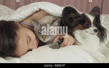 Schöne jugendlich Mädchen süß schlafen im Bett mit Hund und Katze Stockfoto