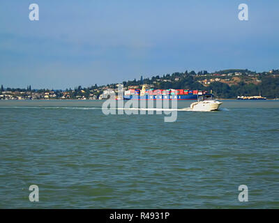 Motorboot und Container Stockfoto