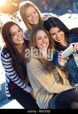 Eine Gruppe von Freunden die Bilder mit einem Smartphone Stockfoto