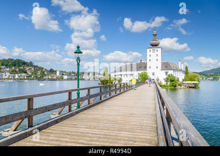 Schönen Blick auf berühmte Schloss Ort mit hölzernen Brücke an den Traunsee an einem sonnigen Tag mit blauen Himmel und Wolken im Sommer, Gmunden, Salzkammergut Stockfoto