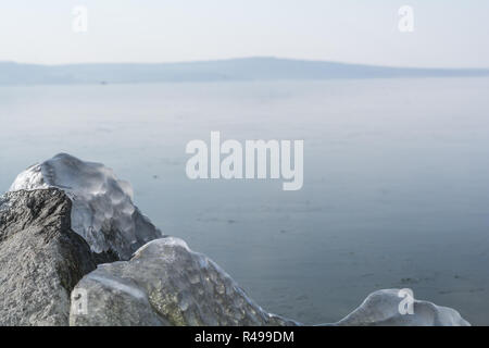 Felsen mit Eis im Winter See eingefroren Stockfoto