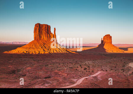 Klassische Ansicht der berühmten Monument Valley mit Schatten des Westens Mitten auf dem Osten Mitten im schönen goldenen Abendlicht bei Sonnenuntergang geworfen werden, Arizona Stockfoto