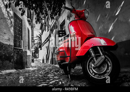 Eine rote Vespa Roller auf einer gepflasterten Straße geparkt Stockfoto