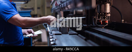 Arbeitnehmer, die eine Metallplatte Stockfoto