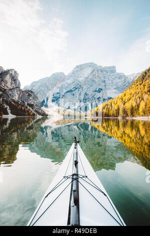 Wunderschöne Aussicht auf Kayak auf einem ruhigen See mit tollen Spiegelungen der Berge und Bäume mit gelben Herbst Laub im Herbst, Lago di Braies, Italien Stockfoto