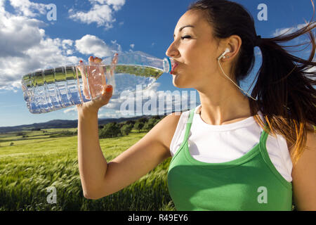 Frau trinkt Wasser nach sportlichen Aktivitäten Stockfoto