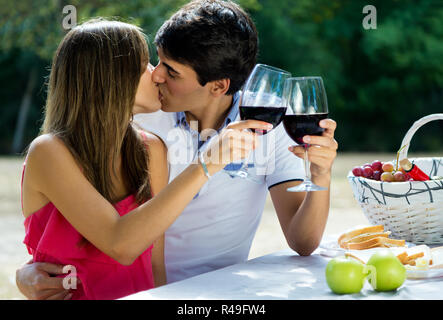 Attraktive paar Wein trinken auf romantischen Picknick im Grünen. Stockfoto