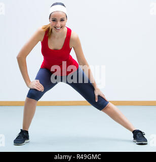 Glückliche junge Frau, etwas Sport in der Turnhalle Stockfoto