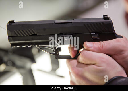 Nürnberg, Deutschland. 05 Mär, 2016. Eine Messe Besucher hält die Ausführung der Pistole P320 der Pistole Hersteller SIG SAUER GmbH & Co.KG am 05.03.2016 an der Jagd und Sporting goods fair OutdoorClassics IWA in Nürnberg (Bayern) auf dem Stand des Unternehmens in der Hand. Credit: Daniel Karmann | Verwendung weltweit/dpa/Alamy leben Nachrichten Stockfoto