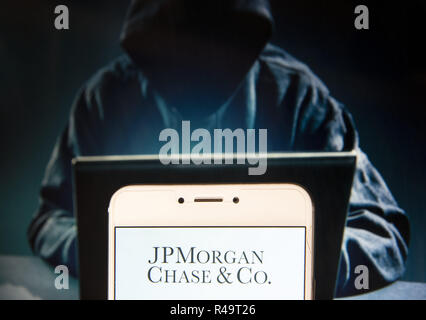 Hong Kong. 23 Nov, 2018. Amerikanische multinationale Investment Bank- und Finanzdienstleistungen Unternehmens JPMorgan Chase & Co Logo ist auf ein Android mobile Gerät mit einer Abbildung der Hacker auf dem Hintergrund gesehen. Credit: Miguel Candela/SOPA Images/ZUMA Draht/Alamy leben Nachrichten Stockfoto