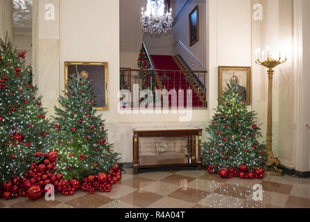 Washington, District of Columbia, USA. 26 Nov, 2018. Die 2018 Weißes Haus Weihnachtsschmuck, mit dem Thema "Amerikanische Schätze", die persönlich von der ersten Dame Melania Trump ausgewählt wurden, sind für die Presse in Washington, DC am Montag, 26. November 2018 in der Voranzeige dargestellt. Diese Ansicht ist der Grand Foyer gerade außerhalb des Osten Zimmer die Treppe rauf zum Wohnsitz. Versteckt hinter Weihnachtsbäume sind Porträts von US-Präsident Jimmy Carter, Links, und US-Präsident Lyndon Baines Johnson, rechts. Credit: Ron Sachs/CNP Credit: Ron Sachs/CNP/ZUMA Draht/Alamy leben Nachrichten Stockfoto