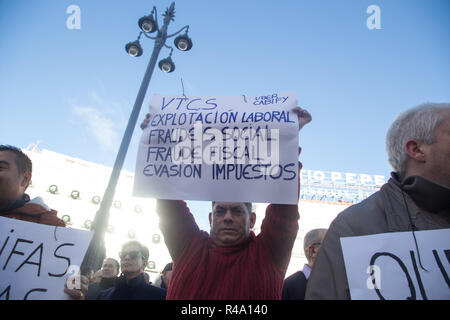 Madrid, Spanien. 26 Nov, 2018. Taxifahrer trägt eine Plakette, prangert die Beschäftigungssituation von Uber oder Cabify Treiber, während des Protestes. Rund 5.000 Taxifahrer, geführt von einer Flotte von Taxi Autos protestiert bei der Gemeinschaft und dem Rat der Stadt die Hauptstadt der "unmittelbare und effektive'' Verordnung der Fahrzeugvermietung mit Fahrer (VTC) wie Uber oder Cabify zu verlangen. Die Demonstration hat am Verwaltungssitz der Gemeinschaft von Madrid an der Puerta del Sol angefangen und ist an der Plaza de Cibeles in Madrid City Hall endete. (Bild: © lito Lizana/SOPA Imag Stockfoto