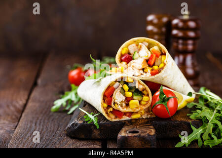 Burritos Wraps mit Hühnerfleisch und Gemüse auf hölzernen Hintergrund Stockfoto