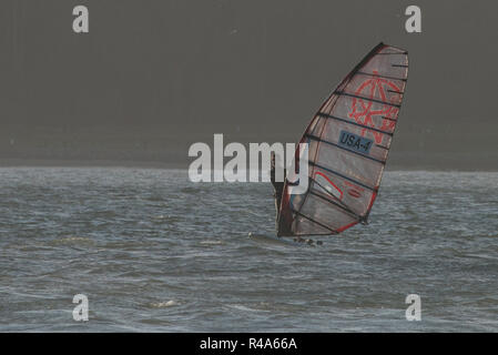 Ein einsamer Surfer in der Bucht von San Francisco rund um das Segeln auf dem ruhigen Wasser. Stockfoto