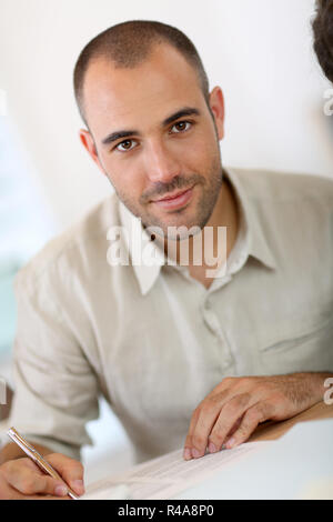 Portrait des jungen Mannes ausfüllen Antragsformular Stockfoto