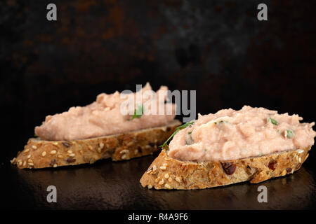 Zwei Scheiben Brot mit Gemüse Pastete auf dunklem Schiefer Stockfoto
