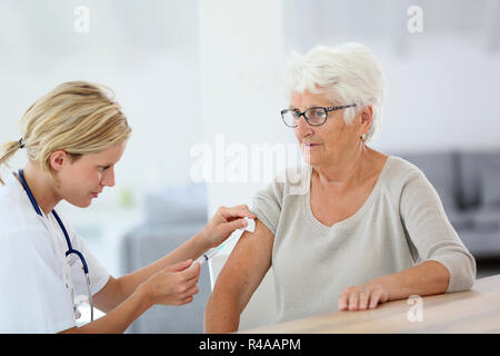 Krankenschwester, Impfstoff Injektion bei älteren Patienten Stockfoto