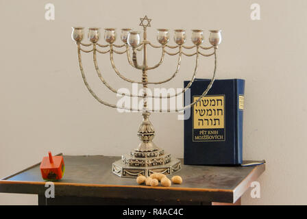 Hanukkia (Kerzenhalter), jüdische Holz dreidl (oben) und das Buch der Tora (Titel in Hebräisch: Der Pentateuch) für die jüdische Feiertag von Hanukkah Stockfoto