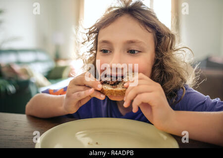 Cute little boy Essen an seinem Esstisch Stockfoto